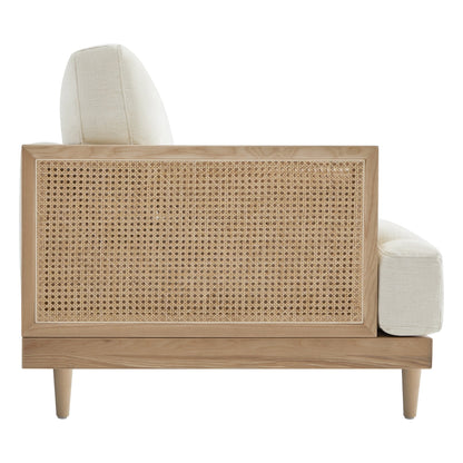 Back view of Julane modern cane armchair showcasing natural rattan weave and light fabric - CHITA Living