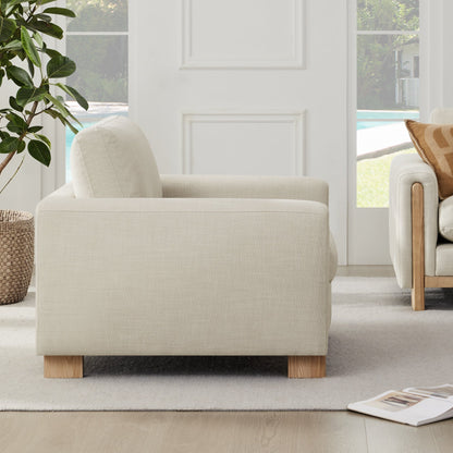 Side view of light gray Keaton Armchair showcasing its plush cushions and wooden legs - CHITA Living