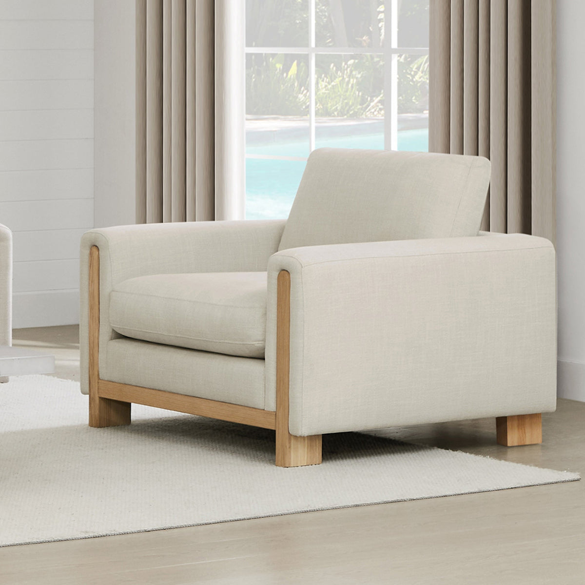 Light gray Keaton Armchair with plush cushion and natural wood frame in a bright room - CHITA Living